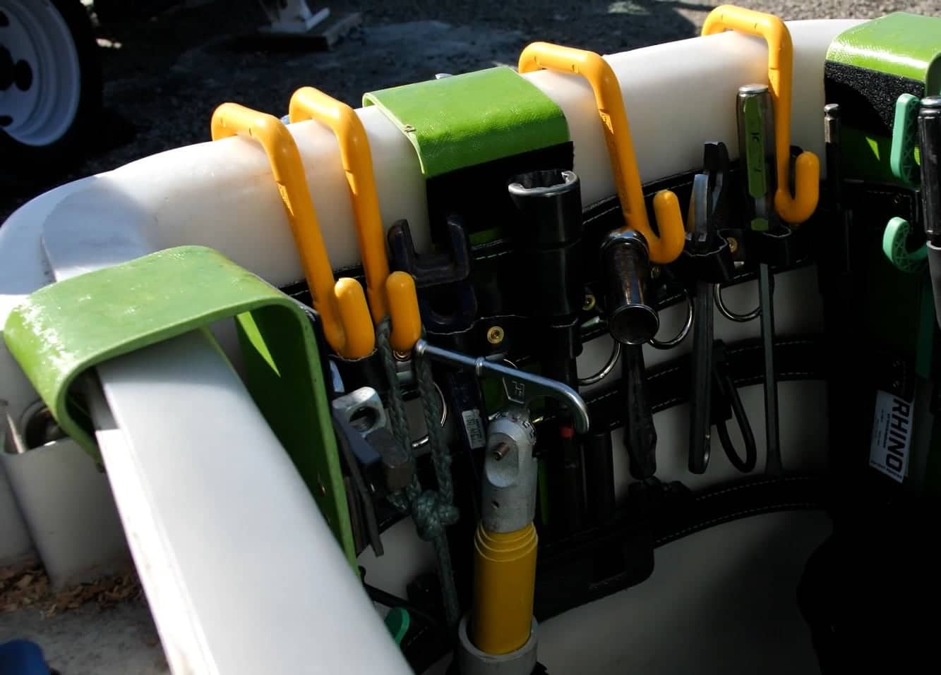 Close-up agricultural sprayer manifold with yellow hooks